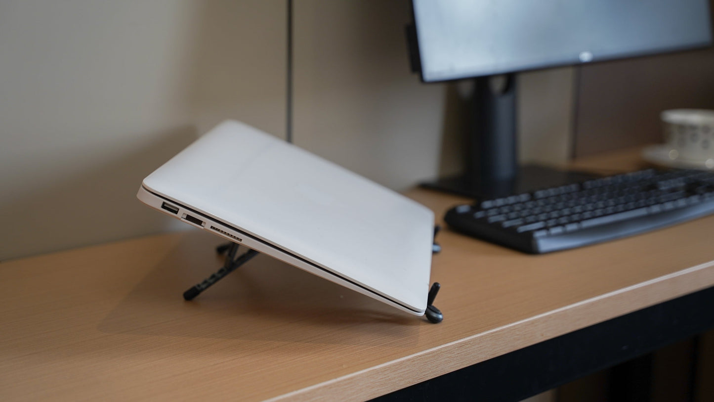 Foldnix magnetic phone stand beside a laptop on a desk