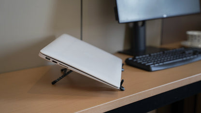 Foldnix magnetic phone stand beside a laptop on a desk